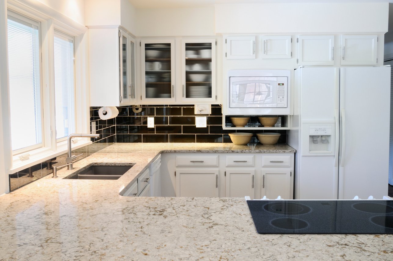 A modern kitchen with white cabinets and countertop